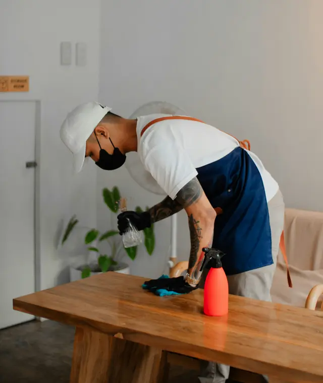 Cleaner spraying and wiping a surface